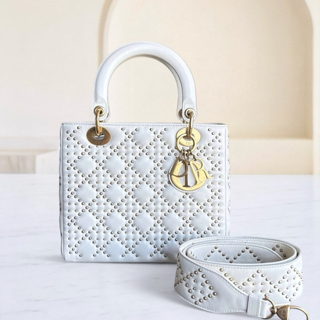 White handbag with gold accents on a light background