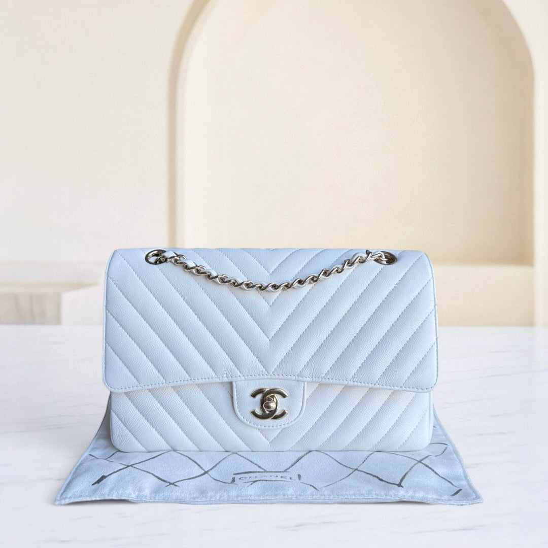 Light blue quilted handbag with gold chain on a white surface