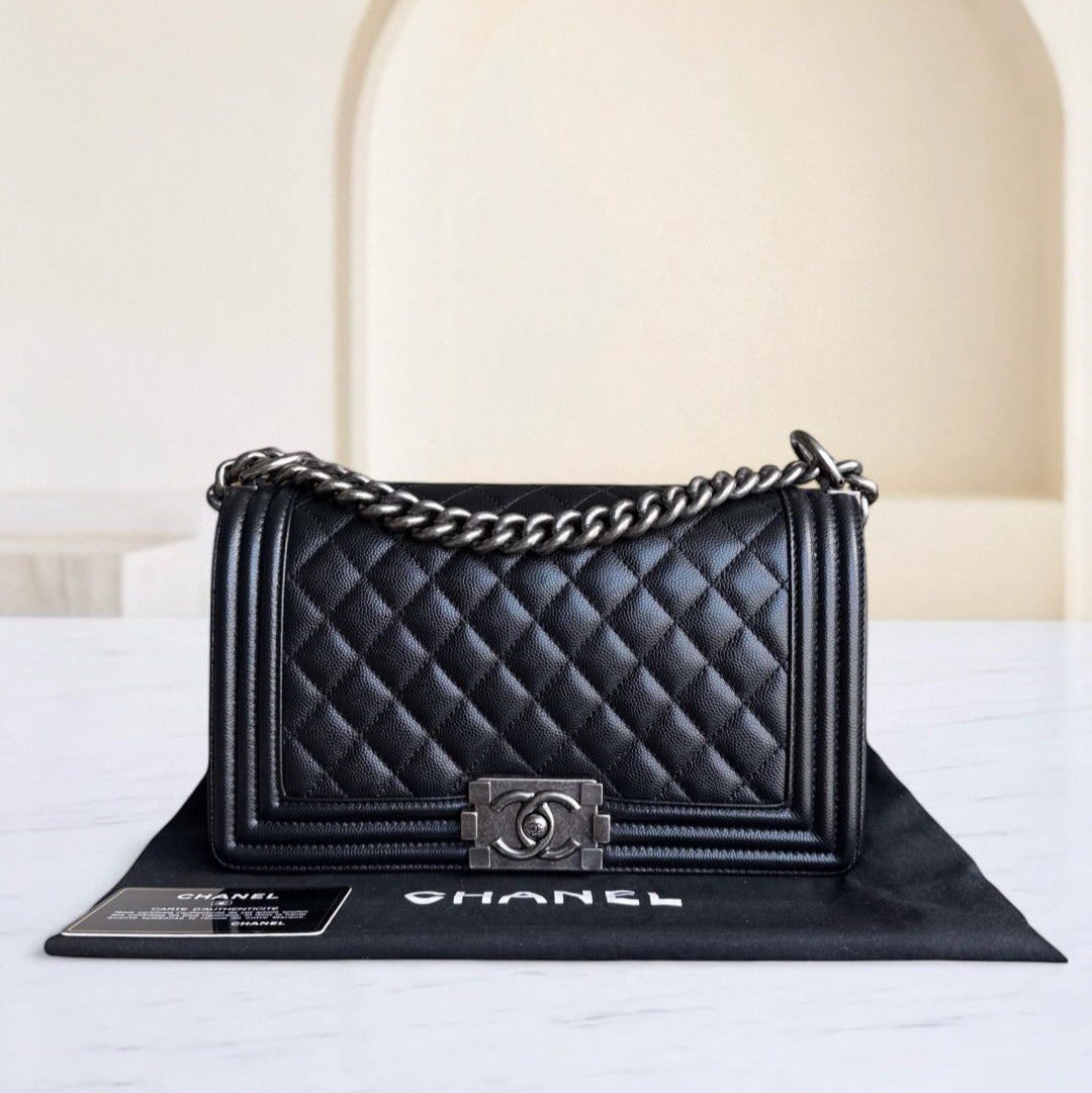 Black quilted Chanel handbag with chain strap on a white surface