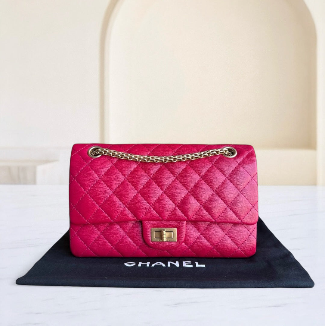 Pink quilted handbag with gold chain on a Chanel logo mat