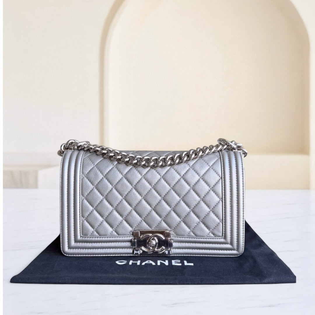 Chanel handbag with chain strap on a branded mat against a neutral background