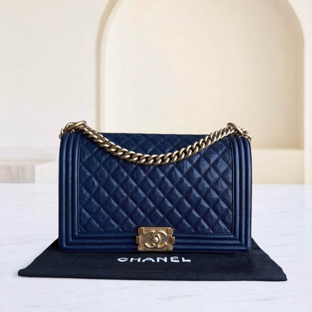 Blue quilted Chanel handbag with gold chain on a white surface