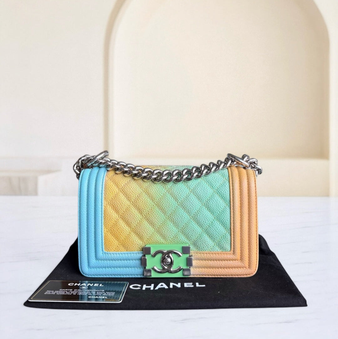 Chanel handbag with a gradient design on a black stand against a white background