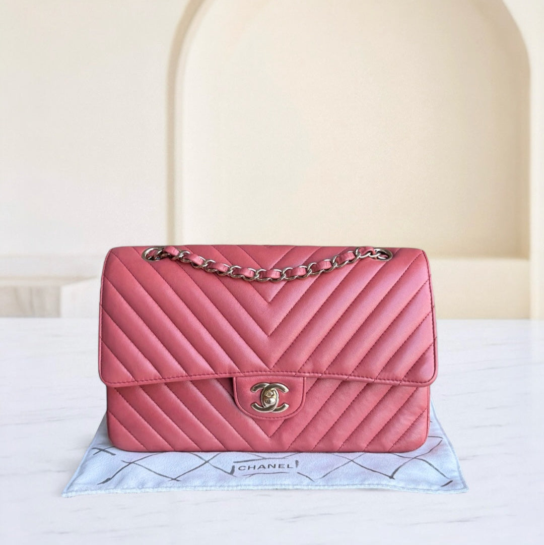 Pink Chanel handbag on a white surface with a light background