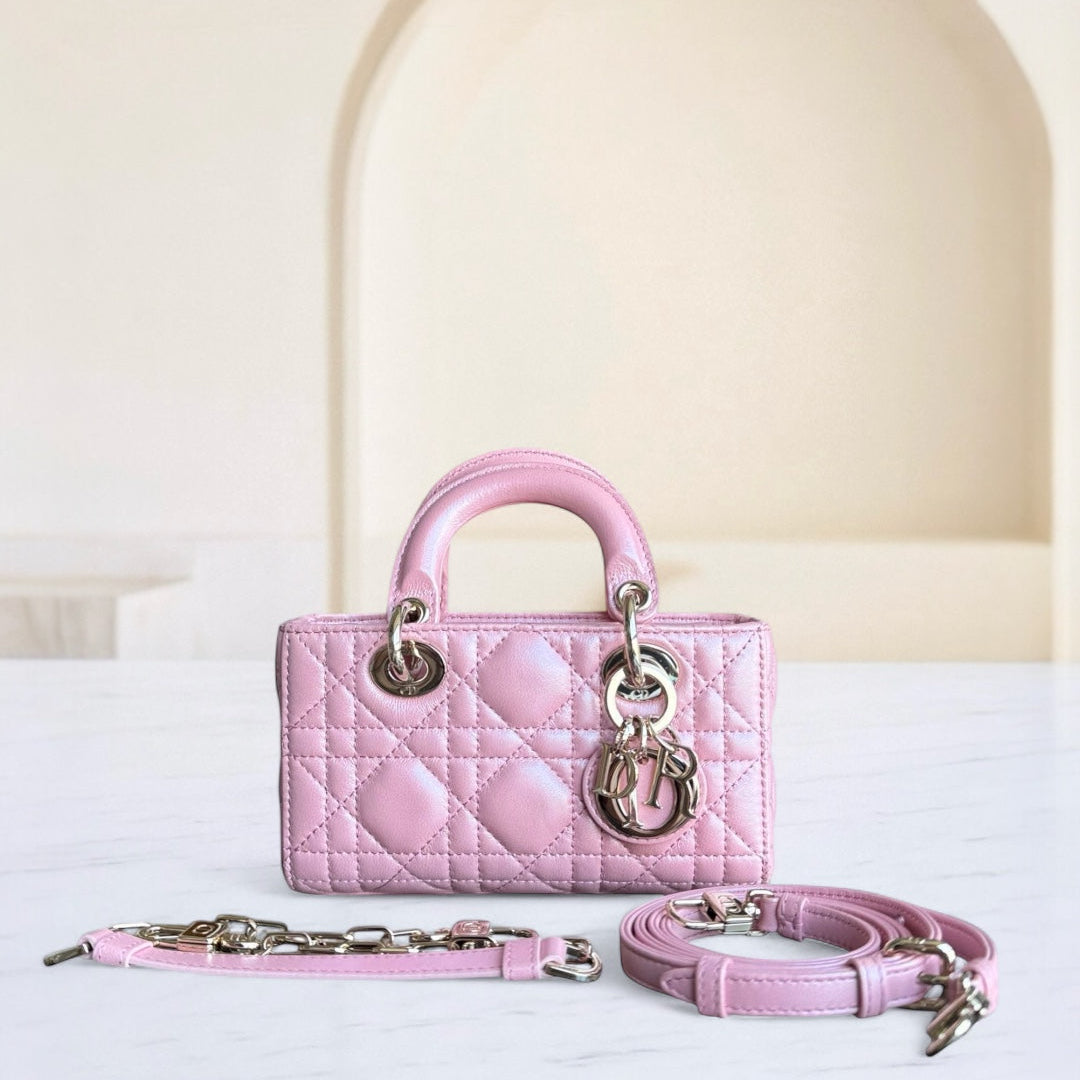 Pink handbag with chain strap on a white surface
