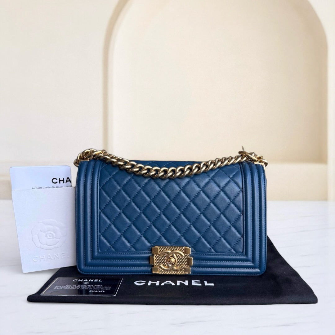 Blue Chanel handbag with gold chain on a white background