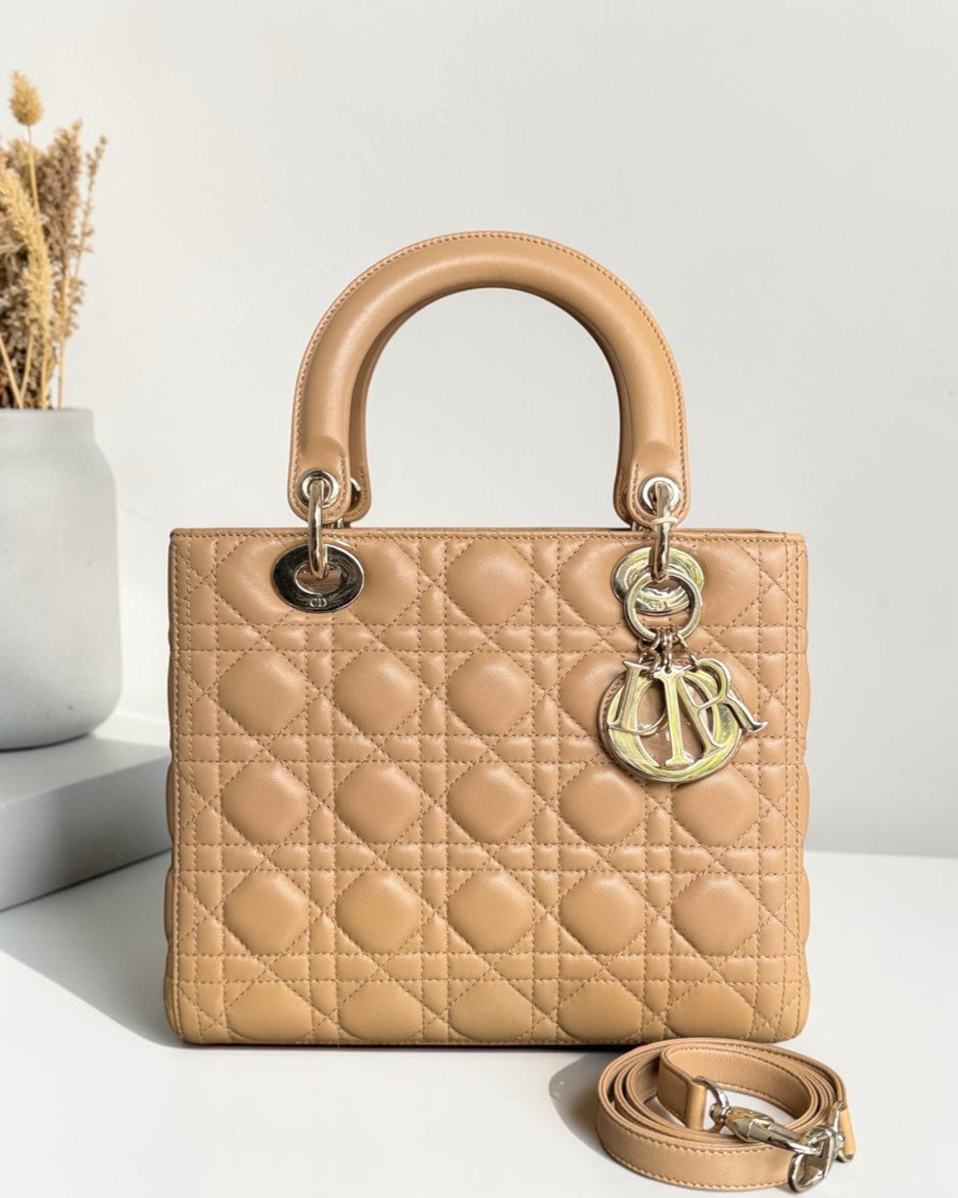 Luxury Evermore medium Dior Lady bag in beige lambskin with iconic cannage stitching and gold-tone hardware charms.