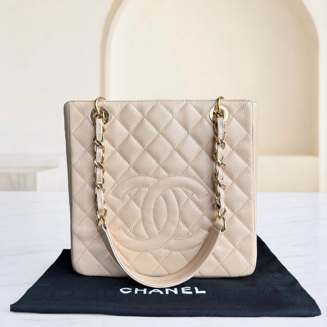 Beige quilted handbag with gold chain on a Chanel branded mat