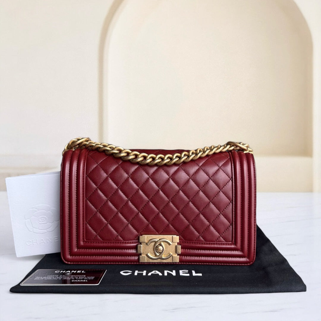 Red quilted Chanel handbag with gold chain on a white surface