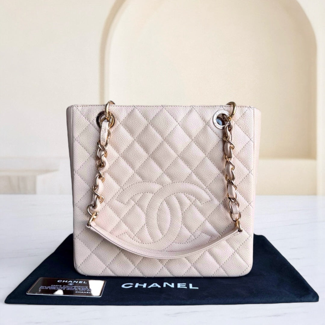 White quilted Chanel handbag on a black Chanel mat with a blurred background