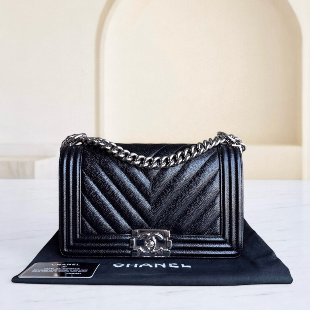 Black Chanel handbag with chain strap on a white surface