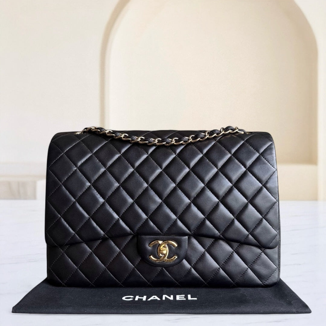 Black quilted Chanel handbag on a white background