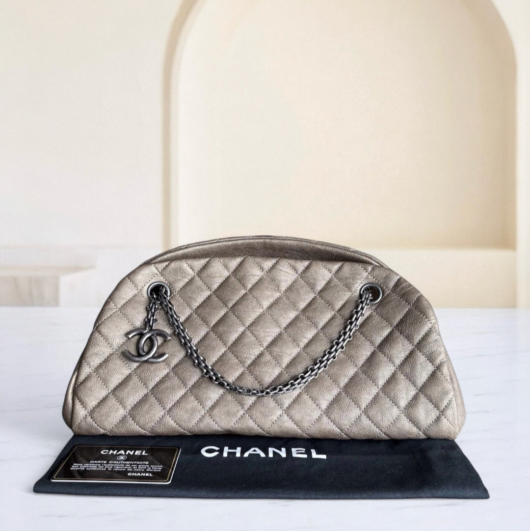 Chanel handbag on a stand with a white background