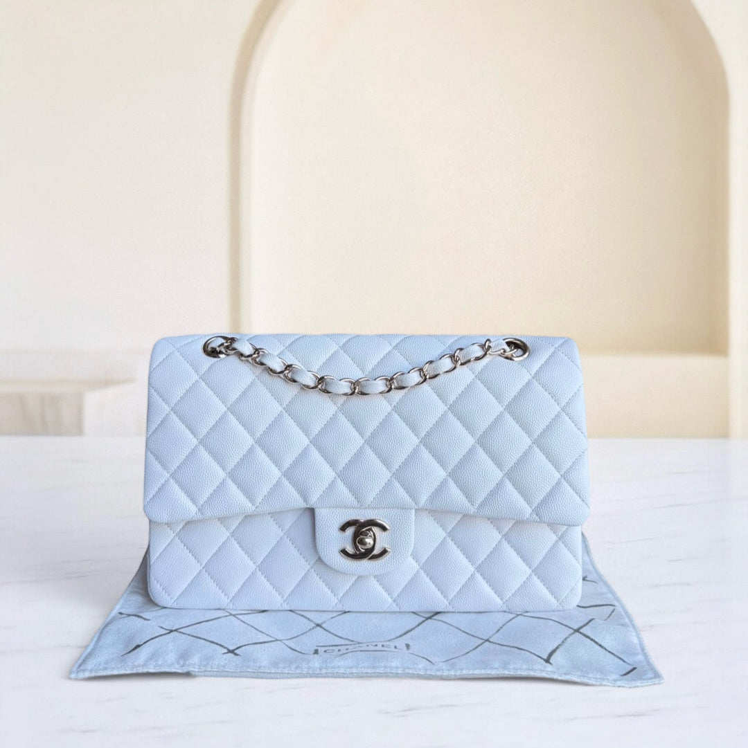 Light blue quilted handbag with Chanel logo on a white surface