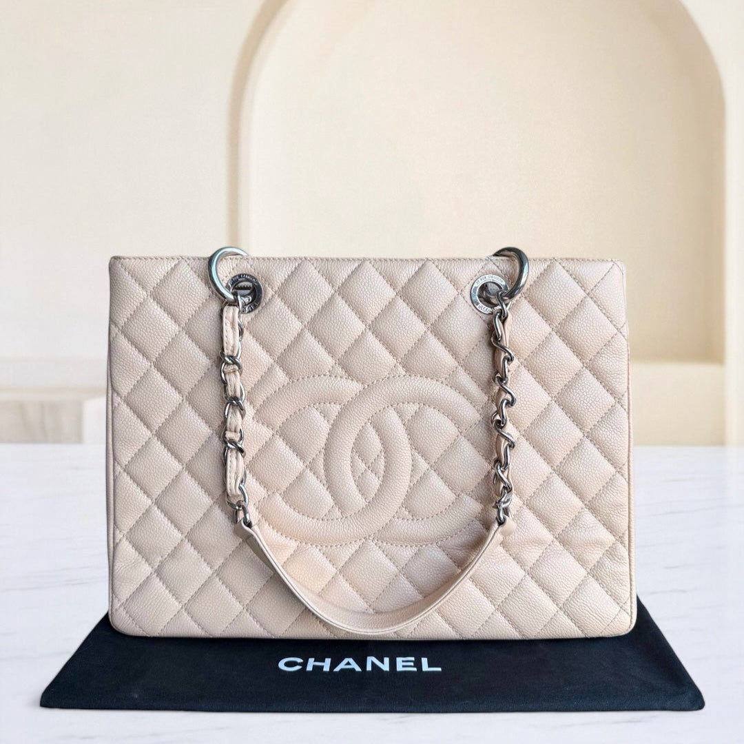 Chanel handbag on a black stand with a white background