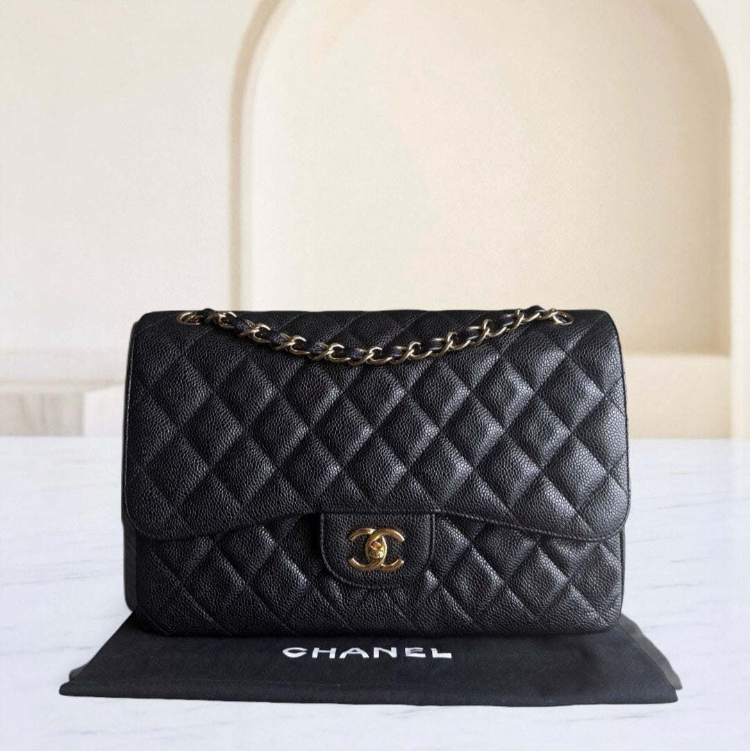 Black quilted Chanel handbag on a white surface with a neutral background
