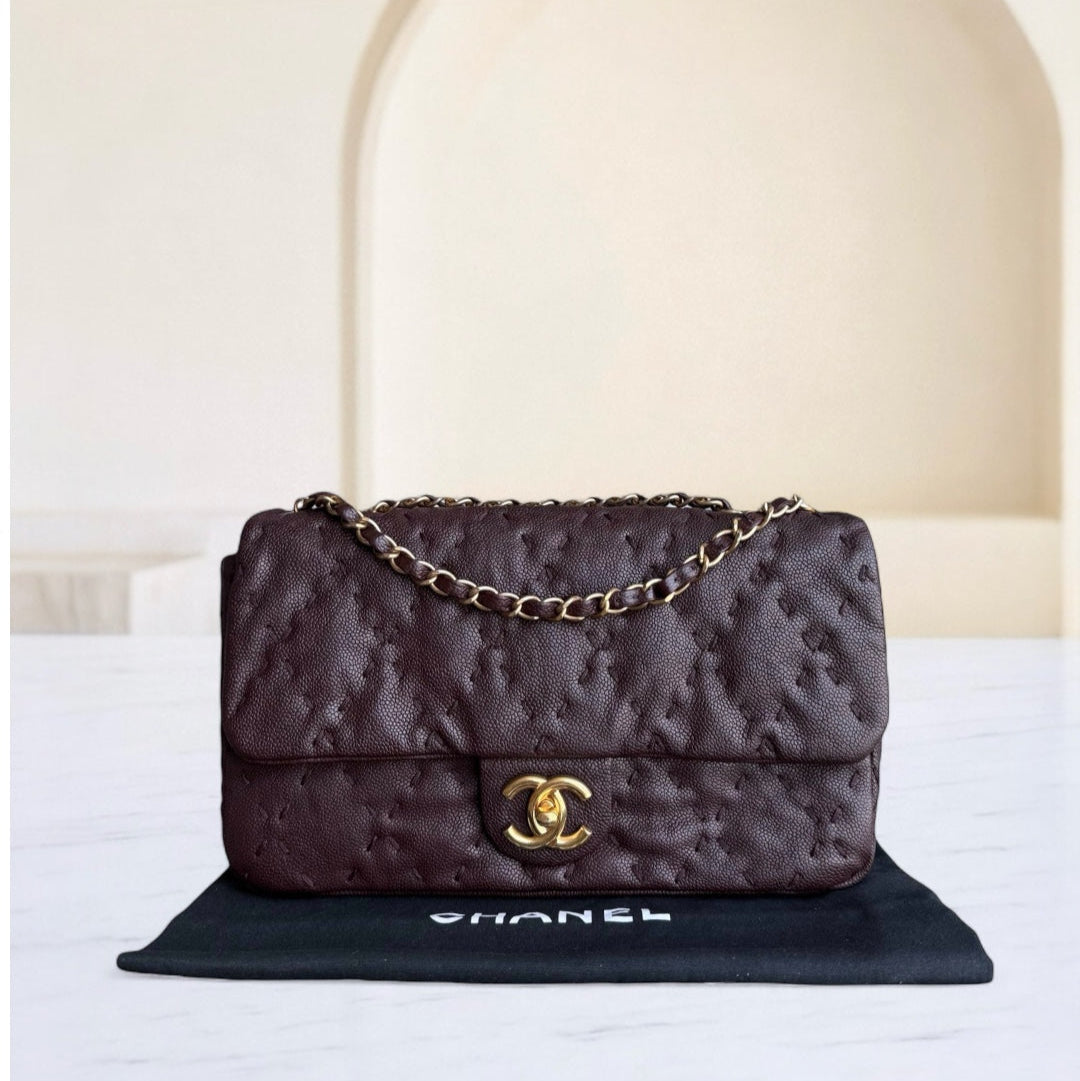 Chanel handbag on a white surface with a neutral background