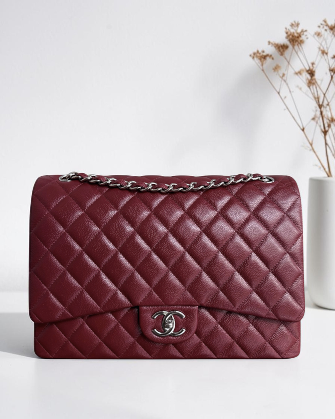 Luxury Evermore 出售的酒红色鱼子酱皮 Chanel Classic Flap Maxi 手袋，配有银色五金件和标志性菱格纹设计