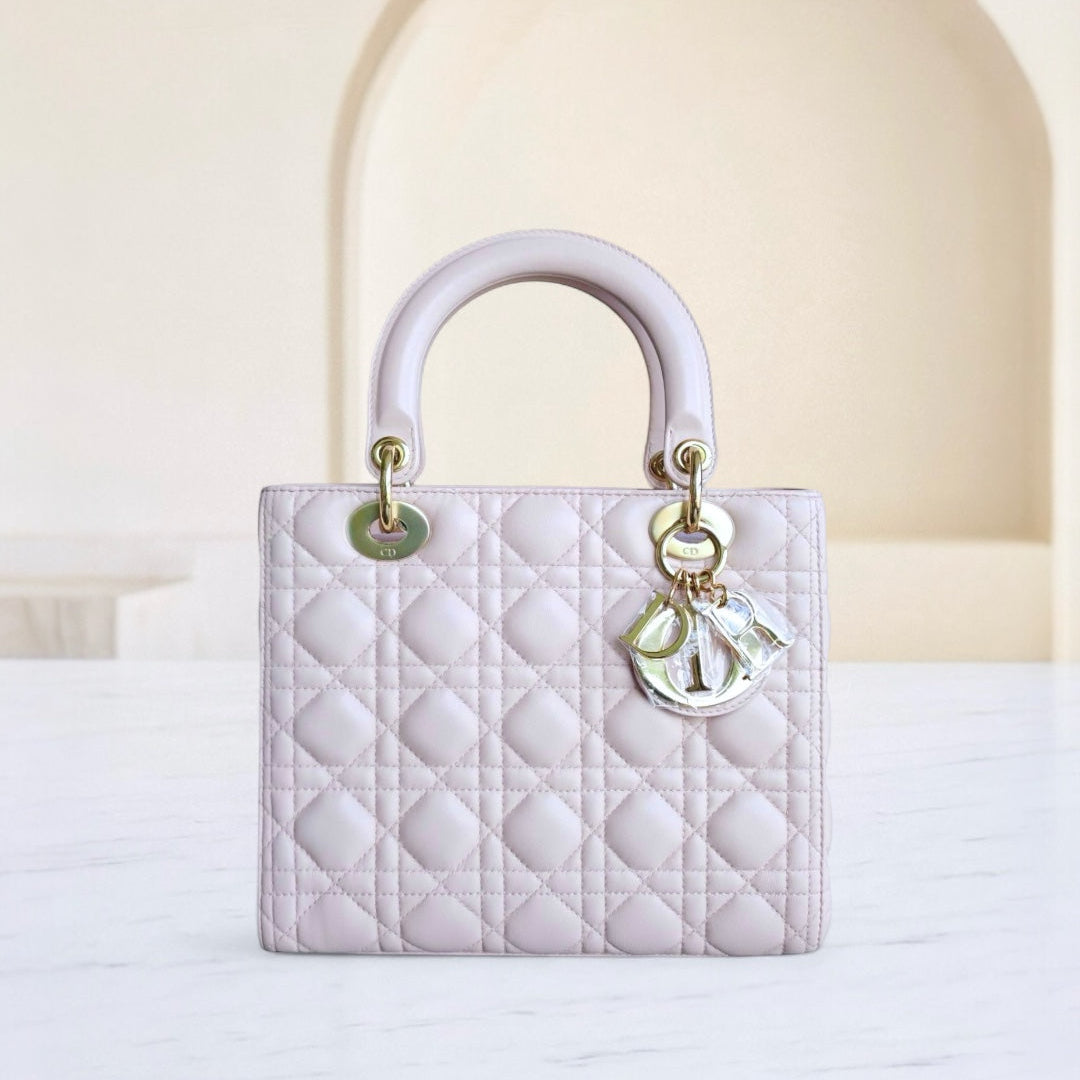 White quilted handbag with gold hardware on a light background