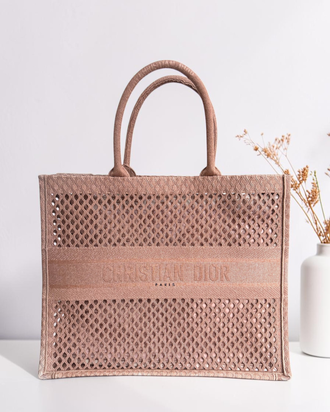 Luxury Evermore 出售的淡粉色 Dior Book Tote 中号手提包，采用精致的镂空刺绣帆布材质，正面饰有经典品牌标识。