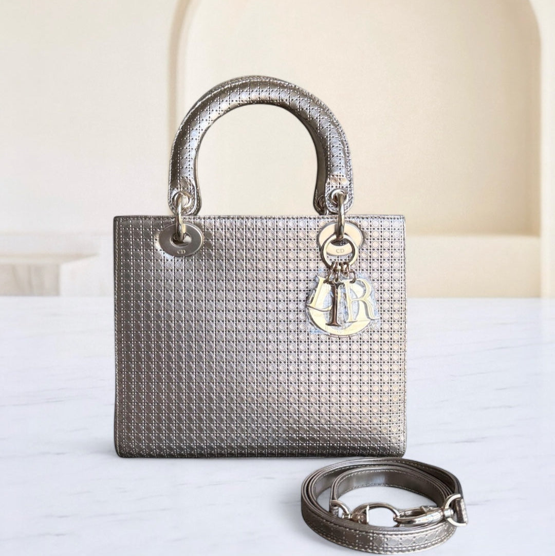 Silver handbag with a matching strap on a white surface