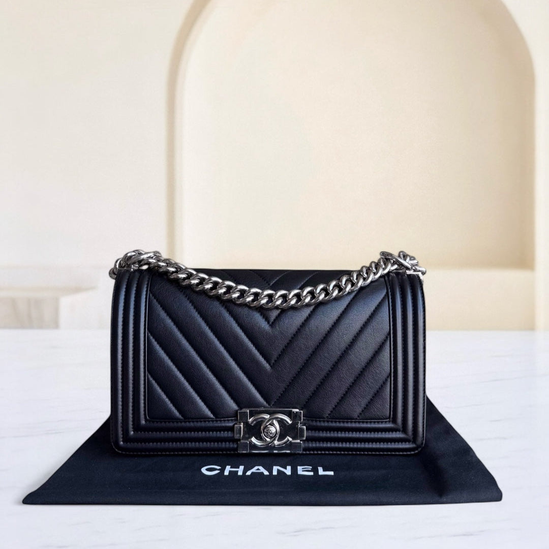 Black Chanel handbag with chain detail on a white surface