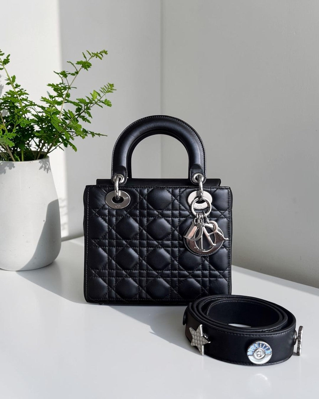 Luxury Evermore black lambskin Dior Lady Small Flap bag with silver hardware and charms, shown with a decorative strap.