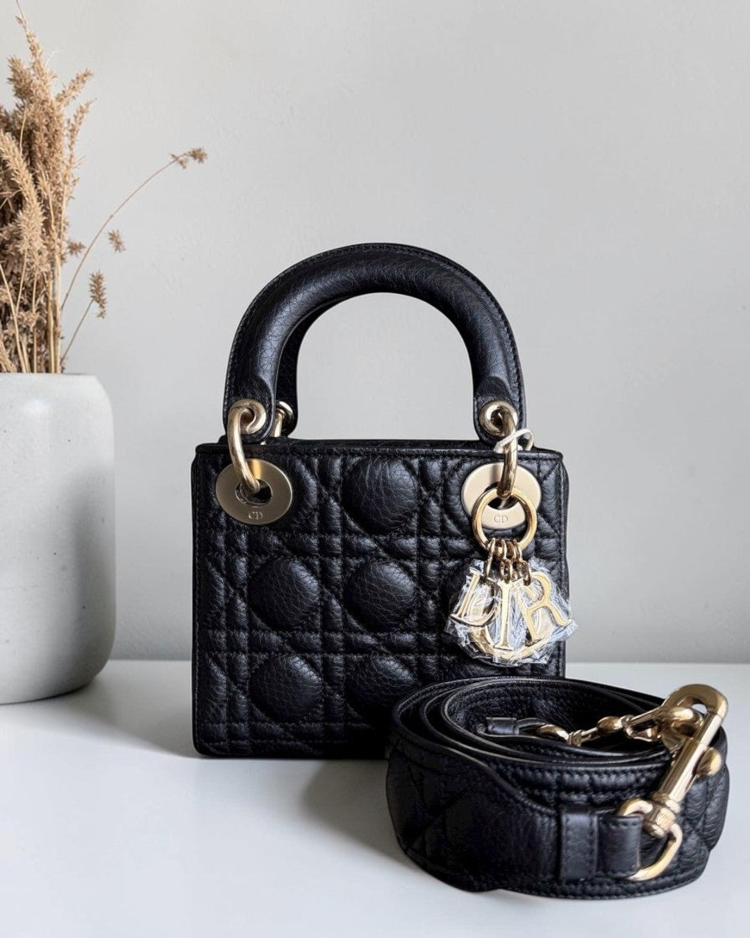 Luxury Evermore black grained calfskin Lady Dior mini bag with iconic cannage stitching and gold-tone hardware.