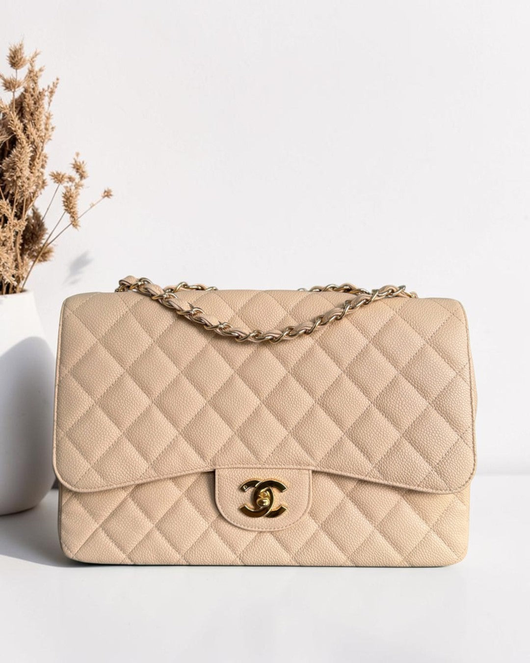 Luxury Evermore Chanel Classic Flap Jumbo bag in beige quilted caviar leather with gold-tone CC turn-lock hardware.