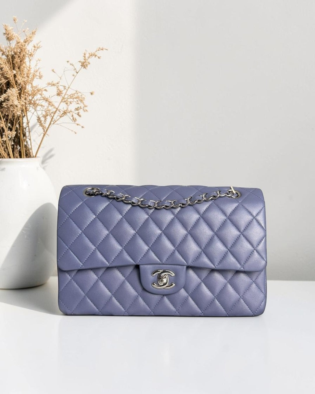 Luxury Evermore Chanel Classic Flap Medium lavender quilted lambskin handbag with silver hardware and chain strap.