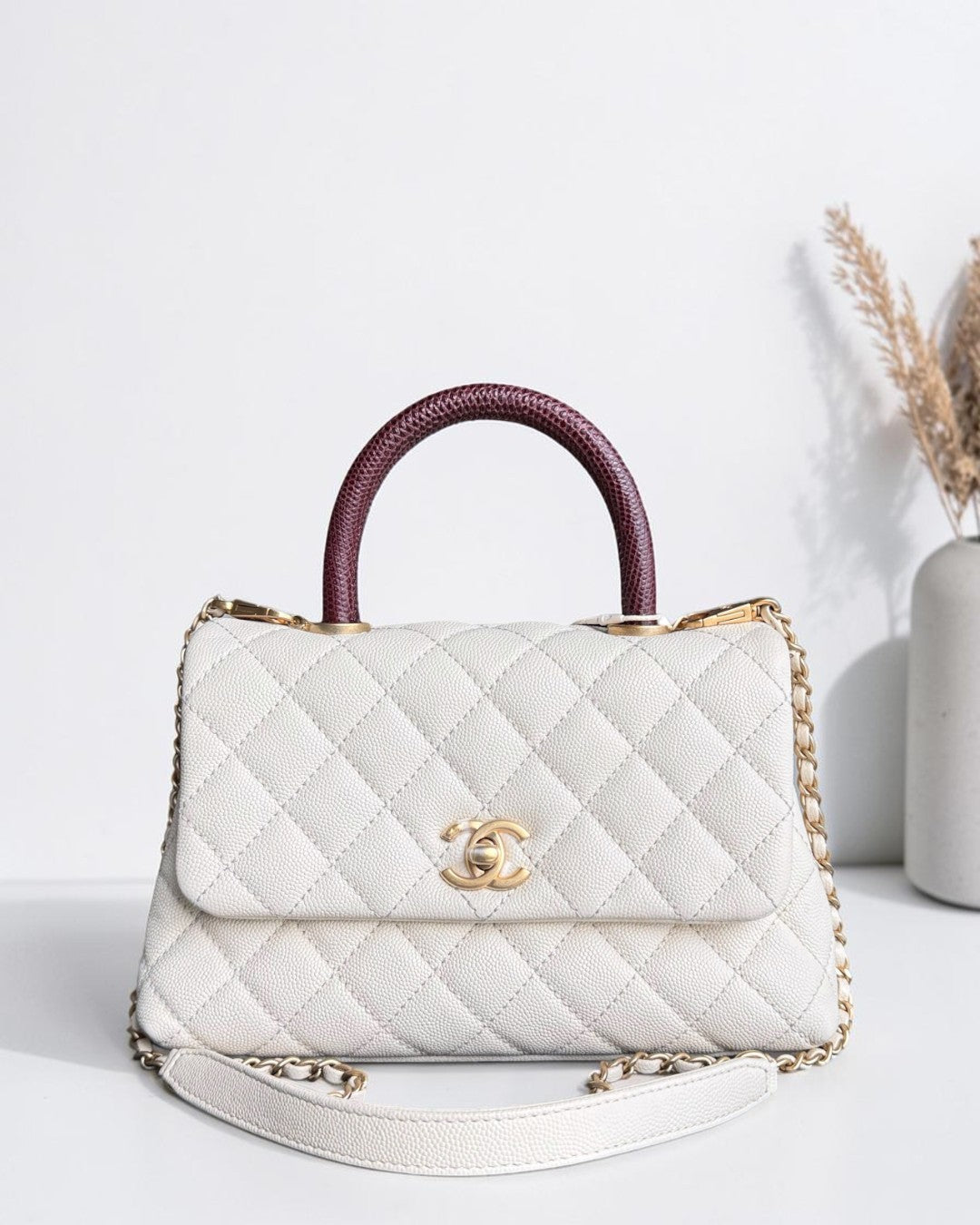 Luxury Evermore Chanel Coco Handle small bag in white quilted caviar leather with a burgundy lizard top handle.
