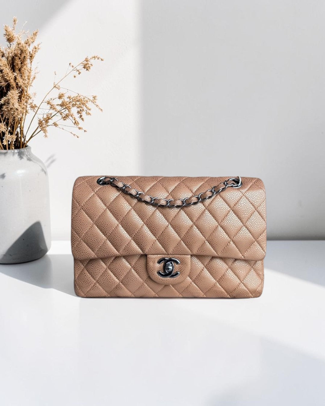 Luxury Evermore Chanel Classic Flap Medium quilted caviar leather handbag in beige with silver hardware and chain strap.